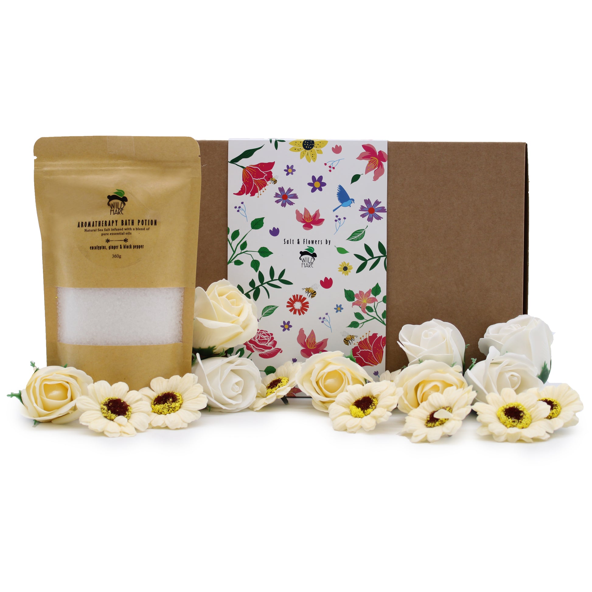 A mixture of cream and white soap Rose and Germini flowers are shown at the front, behind them on the left is a pale brown container of white bath salts, and at the very back is the cardboard box packaging of the giftset, finished with a white floral banner.