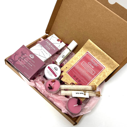 'Coral Bliss' a letterbox of pink and purple products including bath salts, soap bar, organic chocolate, lip balm, candles, face mask and infuser oil.