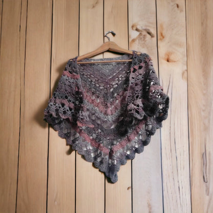 Here you can seen the grey and burgundy colours of our 'Nightfall Crochet Shawl' as well as the crochet pattern used. The shawl is shown here on a hanger on a wood, panelled background.